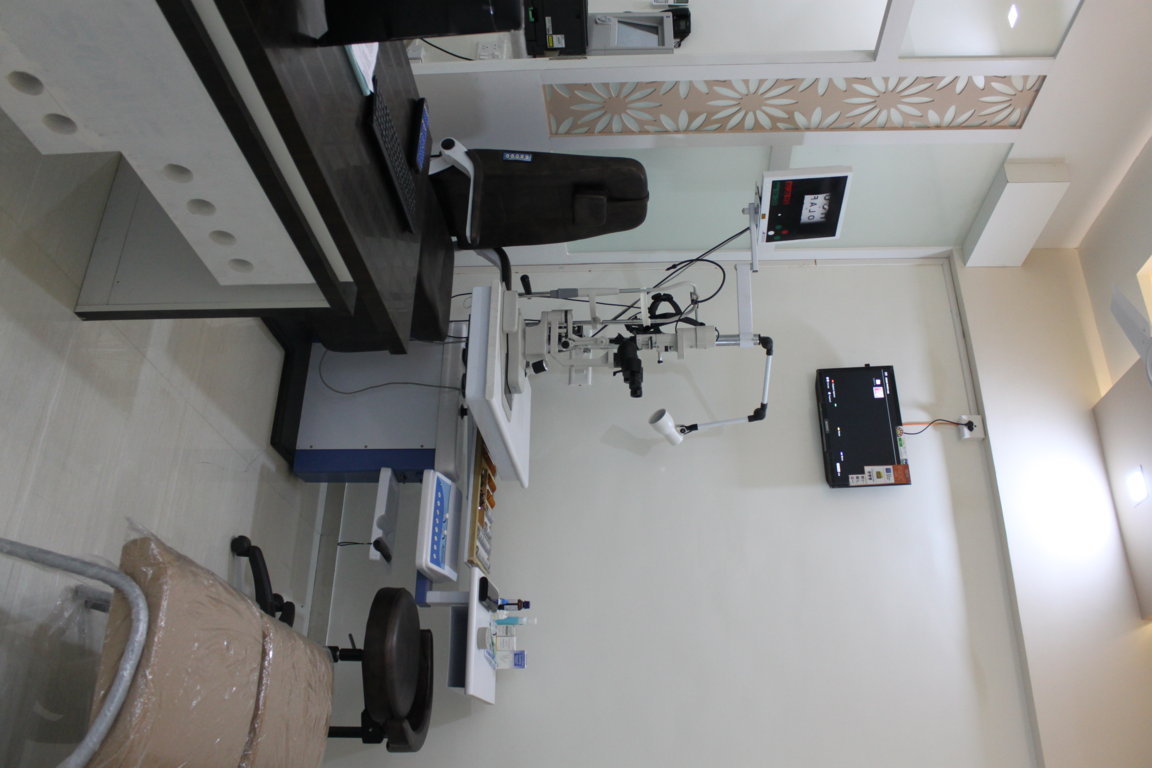 Bird's-eye composition of an Insight Institute slit-lamp examination suite, showing the patient chair, refraction trial-lens trays and overhead monitor